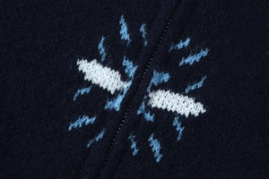 Makroaufnahme einer blauen Strickjacke mit Blitzmuster und Reißverschluss-Detail
