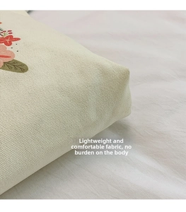 Close-up detail of thickened off-white canvas fabric with floral print and twill texture