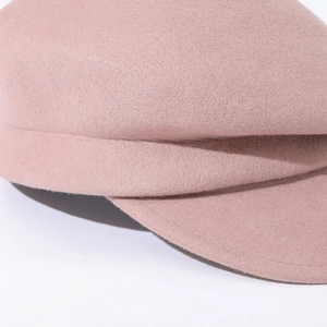 Close-up detail of the pink wool felt baker boy hat showing texture and brim stitching