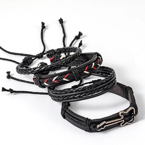 Detail of four-piece rock hip-hop braided leather bracelets with a metal guitar charm