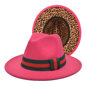 Détail d'un chapeau fedora en laine fuchsia avec bord léopard et ruban rayé rouge et vert