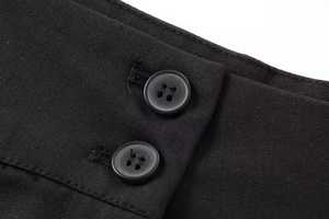 Vue détaillée du tissu en sergé noir avec une fermeture à double boutonnage à la taille