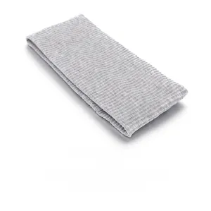 Détail d'un bandeau de sport tricoté gris montrant la texture côtelée et le tissu doux