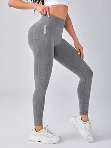 Detailed close-up of high-waisted heather grey yoga pants with gymwear side print