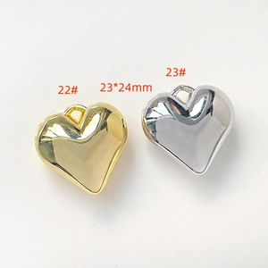 Detailed view of gold and silver heart-shaped polished metal jewelry charms 23x24mm