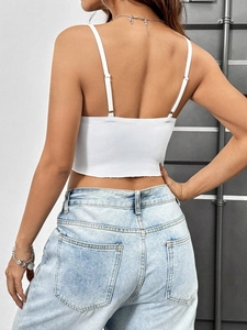 Détail d'un débardeur court blanc présentant une texture de tissu et un dos ouvert chic