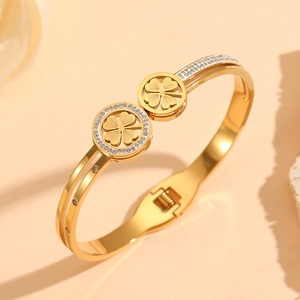 Detail of 18K gold-plated open bangle featuring hollow clover charms with pavé crystals