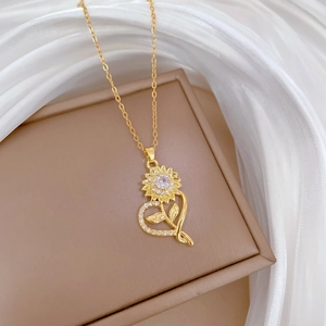 Macro view of crystal pavé sunflower and heart pendant set on a soft jewelry box