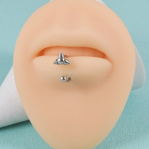 Close-up of silver stainless steel lip ring with spikes on a prosthetic mouth model