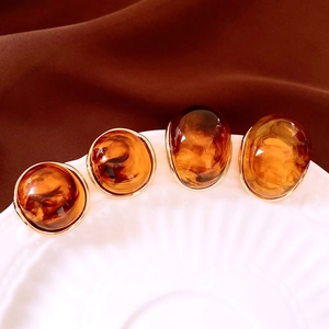 Macro detail of amber resin earrings with elegant gold borders in retro design