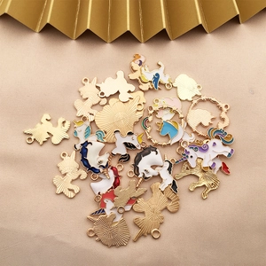 Macro shot of colorful enamel unicorn charms for DIY jewelry on a beige fabric background