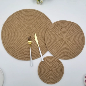 Three-piece set of round woven jute placemats in natural brown for heat insulation