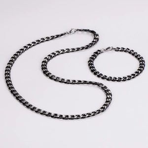 Macro detail of two-tone black and silver 7mm stainless steel Cuban link necklace and bracelet