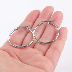 Detalle de pendientes de aro grandes de acero inoxidable plateado con cierre de clic