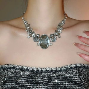Close-up of sparkling silver necklace with a large oval crystal and teardrop accents