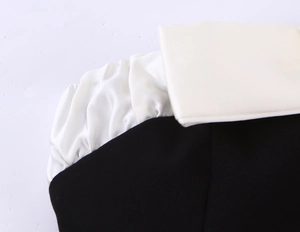 Detailed view of the black fabric and white satin bow stitching on a tube top