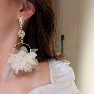 Detailed view of floral drop earrings with white mesh petals and crystal accents