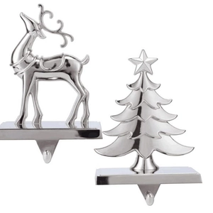 Silver metal Christmas stocking holders with reindeer and tree designs on white background