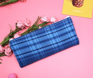 Close-up of blue checkered canvas pencil case with high-capacity zipper and soft fabric
