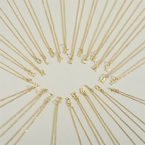 Minimalist gold initial necklace set with 26 letters A-Z in a circular radial arrangement