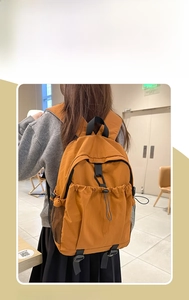Detail des ingwergelben Rucksacks mit vorderem Kordelzugfach und seitlichen Netztaschen
