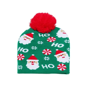 Detailed knit texture of green Christmas beanie with red pompom and Santa snowflake motifs