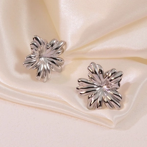 Boucles d'oreilles fleurs 3D en acier titane argenté sur un tissu en soie douce