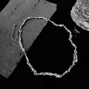 Minimalist silver irregular warped necklace with cool artistic texture on dark surface
