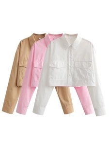 Détail de trois chemises courtes de style cargo en kaki, rose et blanc avec poches