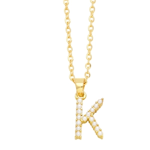Detailed view of golden letter K pendant necklace inlaid with elegant white faux pearls