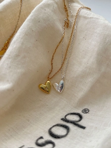 Détail macro de colliers cœur irréguliers en or et argent avec sertissage étoile brillant