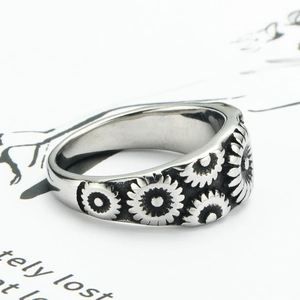 Macro shot of silver stainless steel daisy flower relief ring on illustrated background