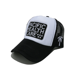 Detail of black and white trucker hat featuring palm tree embroidery and mesh back