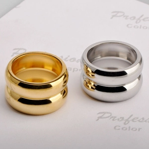 Detail showing polished gold and silver thick dome rings on white textured paper