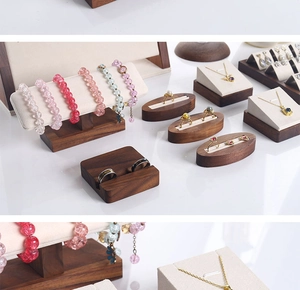 Detail of walnut wood jewelry stand set with beige microfiber displays for necklaces and rings