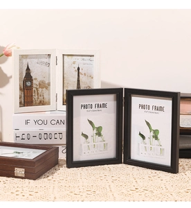 Detail of folding wooden picture frames on lace tablecloth with natural home decor