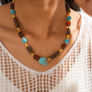 Close-up of ethnic beaded sweater necklace with turquoise and wood beads on model
