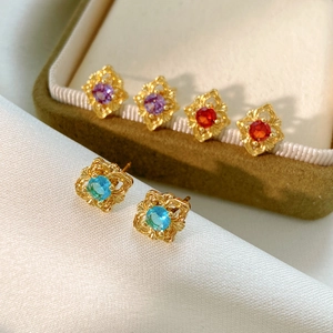 Detailed close-up of vintage style diamond-shaped stud earrings in three elegant gemstone colors