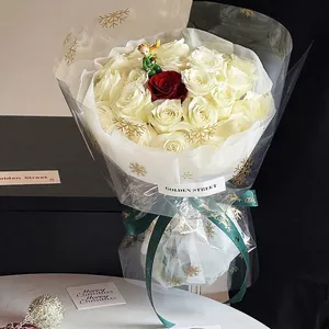 Christmas bouquet wrapping with snowflake transparent cellophane and green festive ribbon