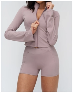 Detail of high-waist shorts with cross V-cut waist and side pockets in mauve color