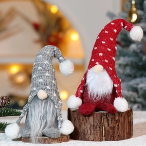 Gnomi natalizi in maglia rossi e grigi su basi di legno con sfondo bokeh accogliente