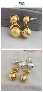Detail view of gold and silver plated spherical earrings in a luxury jewelry box