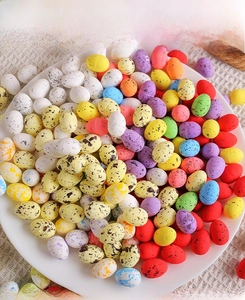 Vue détaillée de mini œufs de Pâques tachetés colorés empilés dans un bol en céramique blanc