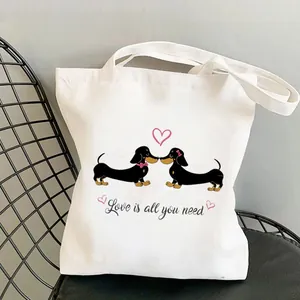 Detail of white canvas tote bag with digital dachshund print and Love is all you need text