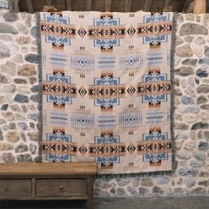 Detailed view of woven geometric pattern and fringe edges on a bohemian picnic blanket