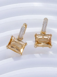 Macro detail of champagne rectangular zircon earrings with micro-pave gold settings
