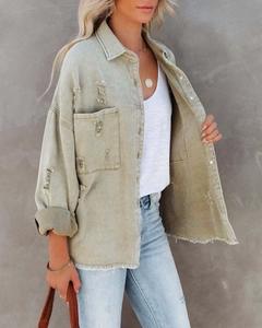 Detail of vintage denim jacket showing loose fit sleeves, lapel, and raw hem edge texture