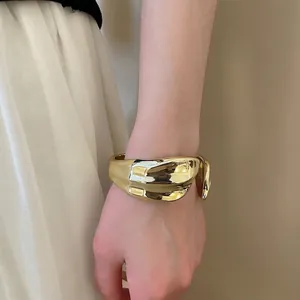 Irregular gold wide-open cuff bracelet with a polished finish and avant-garde style