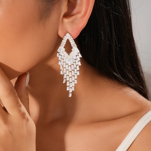 Detail of silver long tassel earrings with baguette zircons worn by a model