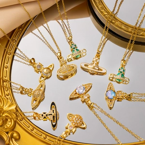 Golden Saturn necklaces with colorful zircon stones on vintage mirror and silk